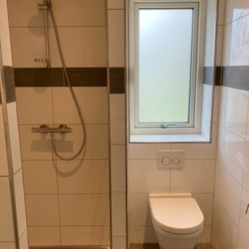 Flisearbejde ved toilet og bruseniche i badeværelse i Varde