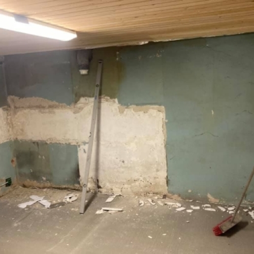 Start på kælderrenovering med nedslidt væg og gamle overflader