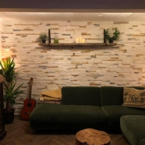 Murerarbejde med naturstensvæg og lyse fliser i stue i Esbjerg