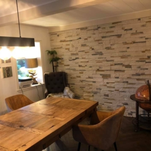 Flisearbejde med naturstensvæg i spisestue – mureropgave i Esbjerg