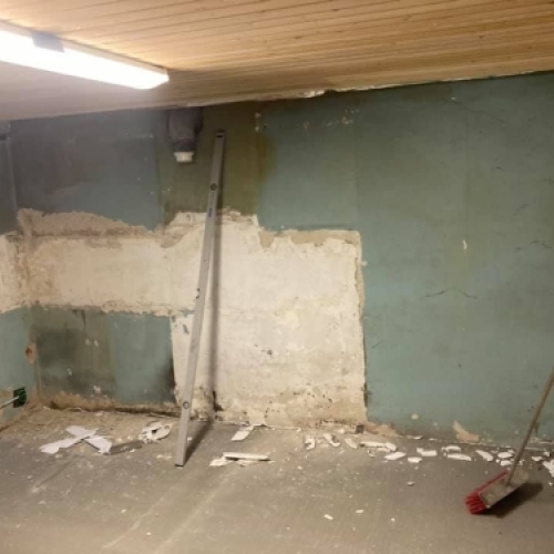 Start på kælderrenovering med nedslidt væg og gamle overflader