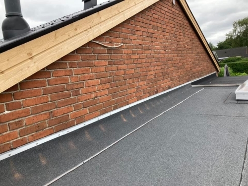 Facaderenovering i Esbjerg med ny murstensvæg under tag